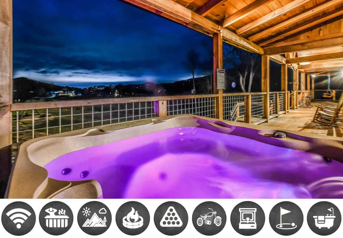 The image shows the exterior of a luxurious wooden cabin nestled in the scenic hills of Wears Valley, Tennessee. The main focal points are a bubbling hot tub on the spacious deck, inviting guests to relax while soaking in panoramic mountain views. The tranquil landscape stretches out as far as the eye can see, with the warm glow of the cabin creating a sense of comfort and serenity.